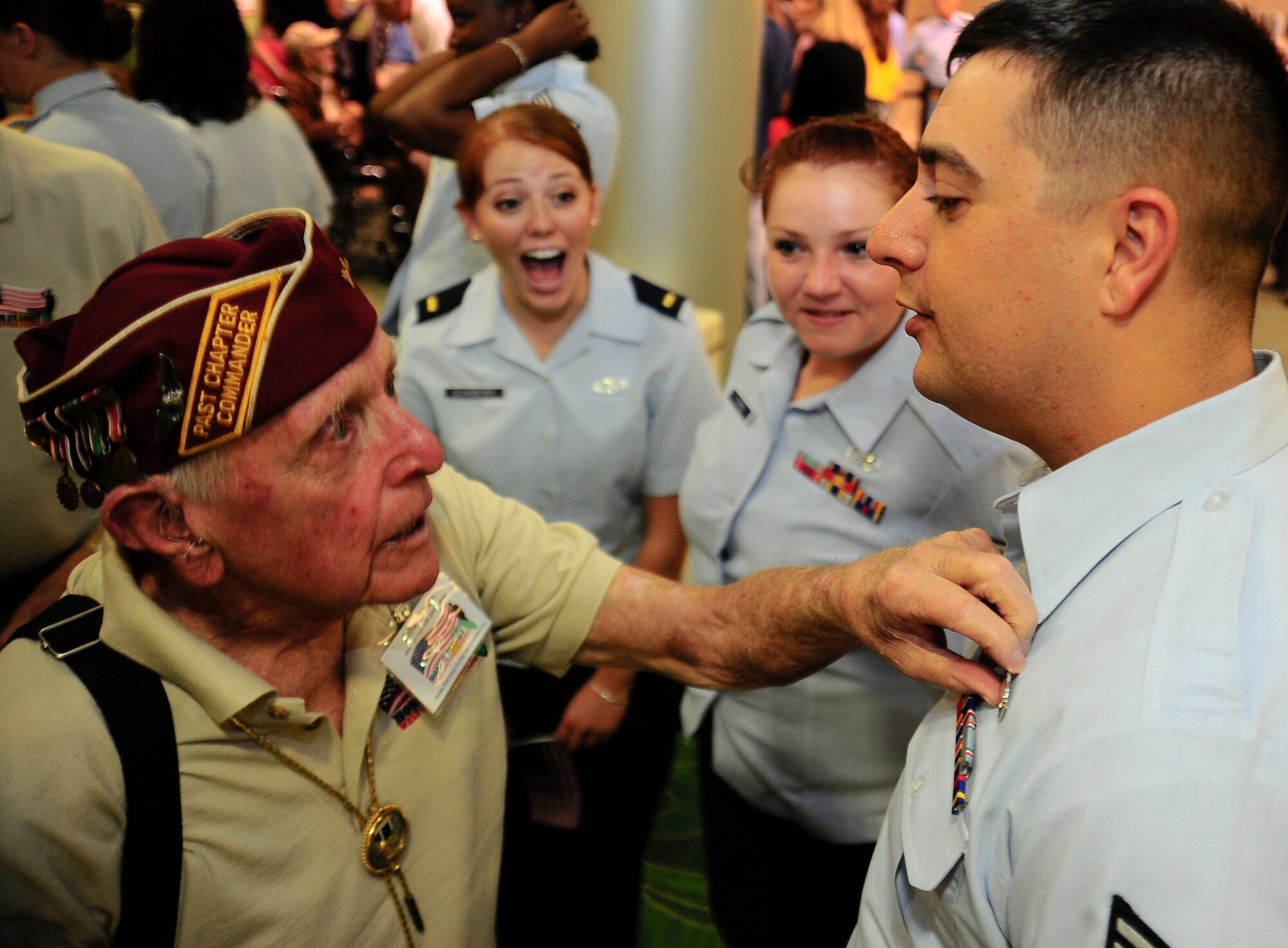 World War II veteran John Crosby discusses Senior Airman Adam Gilreaths’ accouterments at the St Petersburg Clearwater International Airport, Fla., upon the return of the seventh Honor Flight of West Central Florida Sept. 18, 2012. The HFWCF has flown 466 WWII veterans to Washington D.C. (U.S. Air Force photo by Staff Sgt. Angela Ruiz)