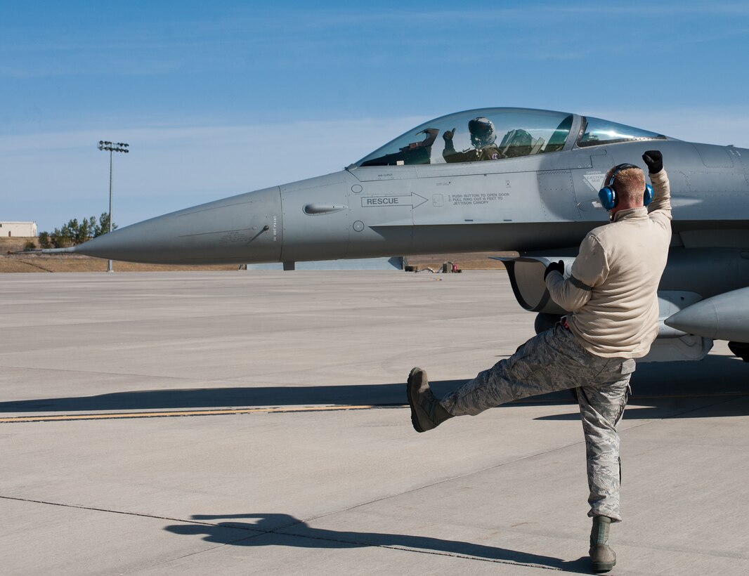 Tech. Sgt.  Christopher Thesenvitz, 175th Fighter Squadron crew chief, marshals Capt. Travis Barnett, 114th Fighter Wing F-16 pilot, during the South Dakota Air National Guard’s 2012 Live Drop exercise at Ellsworth Air Force Base, S.D., Sept. 19, 2012. The exercise helped to validate F-16 tactics, techniques and procedures during long-range strike missions. (U.S Air Force photo by Airman 1st Class Alystria Maurer/Released)