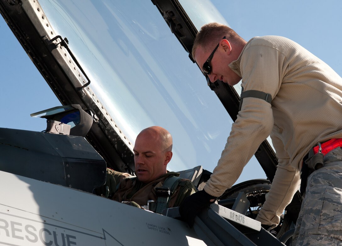 Tech. Sgt.  Christopher Thesenvitz, 175th Fighter Squadron crew chief, assists Capt. Travis Barnett, 175th FS F-16 pilot, in checking his gear prior to engine start during the South Dakota Air National Guard’s 2012 Live Drop exercise at Ellsworth Air Force Base, S.D., Sept. 19, 2012. The F-16 is highly maneuverable and has proven itself both in air-to-air combat and air-to-surface operations. (U.S Air Force photo by Airman 1st Class Alystria Maurer/Released)