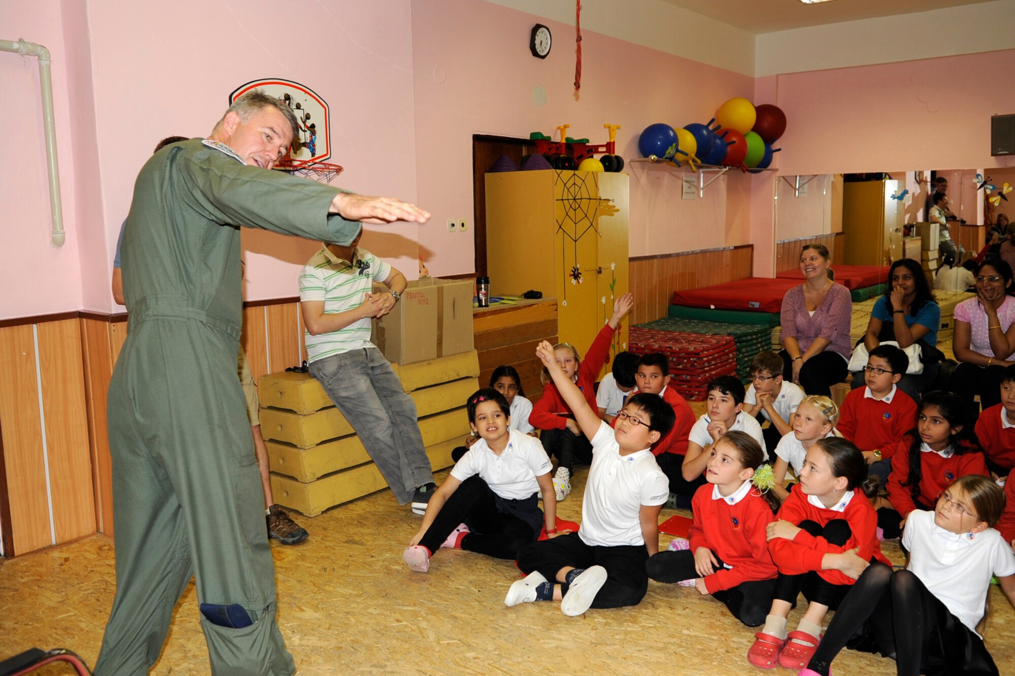Lt. Col. Robert VanHoy, the 93rd Bomb Squadron director of operations explains how the wing of a B-52 Stratofortress flexes during flight to a group of 8-10 year old students from the 1st International School of Ostrava during a visit Sept. 19, 2012. The aircrew visited the school and answered questions from the students relating to their military jobs. The wing is participating in the NATO Days Air Show in Ostrava, Czech Republic, where they are displaying a B-52 Sept. 22-23. (U.S. Air Force photo by Senior Master Sgt. Jessica Daurizio/Released)