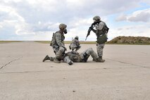MINOT AIR FORCE BASE, N.D. -- Airmen from the 91st Security Forces Group’s Global Strike Challenge team, prepare to 2mancarry their wingman during a training scenario here, Sept.6. Minot Airmen from both the 5th Bomb Wing and the 91st Missile Wing are participating in this year's Air Force Global Strike Command Global Strike Challenge during the months of June through November to showcase the world's premier bomber and ICBM forces and to recognize outstanding AFGSC personnel and teams.    (U.S. Air Force photo/Senior Airman Brittany Y. Auld)