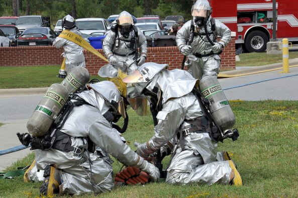 Firefighters from the 4th Civil Engineer Squadron prepare their hoses before entering a building after a simulated attack during Phase II of Operational Readiness Exercise Coronet Warrior 12-04 at a simulated deployed location on Seymour Johnson Air Force Base, N.C., Sept. 20, 2012. The evaluators tested the wing's ability to rapidly deploy, survive and operate under simulated conventional, chemical and biological conditions. (U.S. Air Force photo/Staff Sgt. Courtney Richardson/Released)