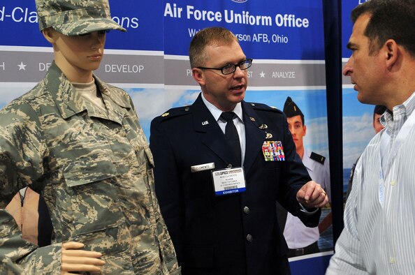 Maj. Robert Clements, U.S. Air Force Uniform Office deputy chief, speaks to Staff Sgt. George Curley, 102nd Network Warfare Squadron, Rhode Island Air National Guard, about the new Rip-Stop Airman Battle Uniform, featuring a lighter nylon-cotton blend fabric that became available last June. The Air Force Uniform Office sent representatives to last year's Air Force Association Air and Space Conference and Technology Exposition, Washington D.C., Sept. 17-19, 2012, to spread the word about recent improvements and updates to Air Force gear. (U.S. Air Force photo by Senior Airman Steele C. G. Britton) 
