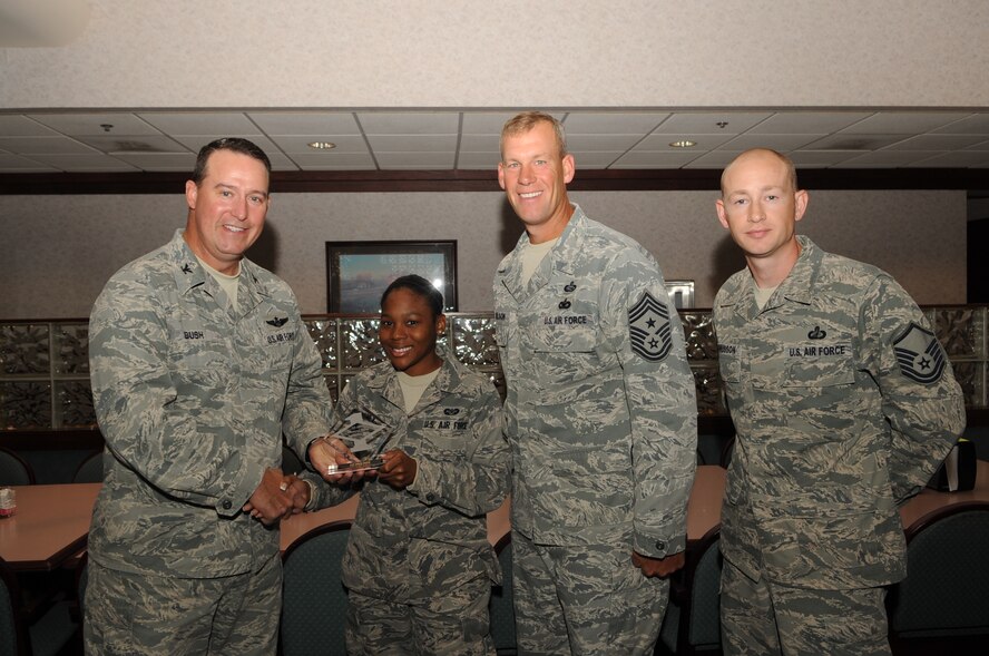 Col. Timothy Bush, 319th Air Base Wing commander, presents Airman 1st Class Adena Coney, 319th Wing Staff Agencies, with a Diamond Sharp Award Sept. 20, 2012, on Grand Forks Air Force Base, N.D., accompanied by 319th ABW Command Chief Master Sgt. David Carlson and Master Sgt. Keelan Rasmusson, 319th WSA acting First Sergeant. The Diamond Sharp Award is given to Airmen who epitomize service before self and strive for excellence at work and off duty. (U.S. Air Force photo by Staff Sgt. Amanda N. Grabiec)