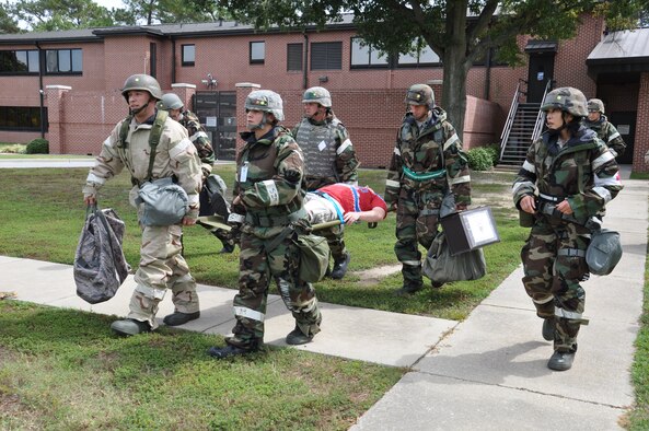 Airmen from the 4th Fighter Wing litter carry a mock patient to a bunker after an attack during Phase II of Operational Readiness Exercise Coronet Warrior 12-04 at a simulated deployed location on Seymour Johnson Air Force Base, N.C., Sept. 20, 2012. Many Airmen assisted exercise evaluators by posing as hostile forces and moulage patients. (U.S. Air Force photo/Staff Sgt. Courtney Richardson/Released)
