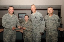 Col. Timothy Bush, 319th Air Base Wing commander, presents Senior Airman Alexandra Crawley, 319th Force Support Squadron, with a Diamond Sharp Award Sept. 20, 2012, on Grand Forks Air Force Base, N.D., accompanied by 319th ABW Command Chief Master Sgt. David Carlson and Master Sgt. Lyance Savage, 319th FSS First Sergeant. The Diamond Sharp Award is given to Airmen who epitomize service before self and strive for excellence at work and off duty. (U.S. Air Force photo by Staff Sgt. Amanda N. Grabiec)