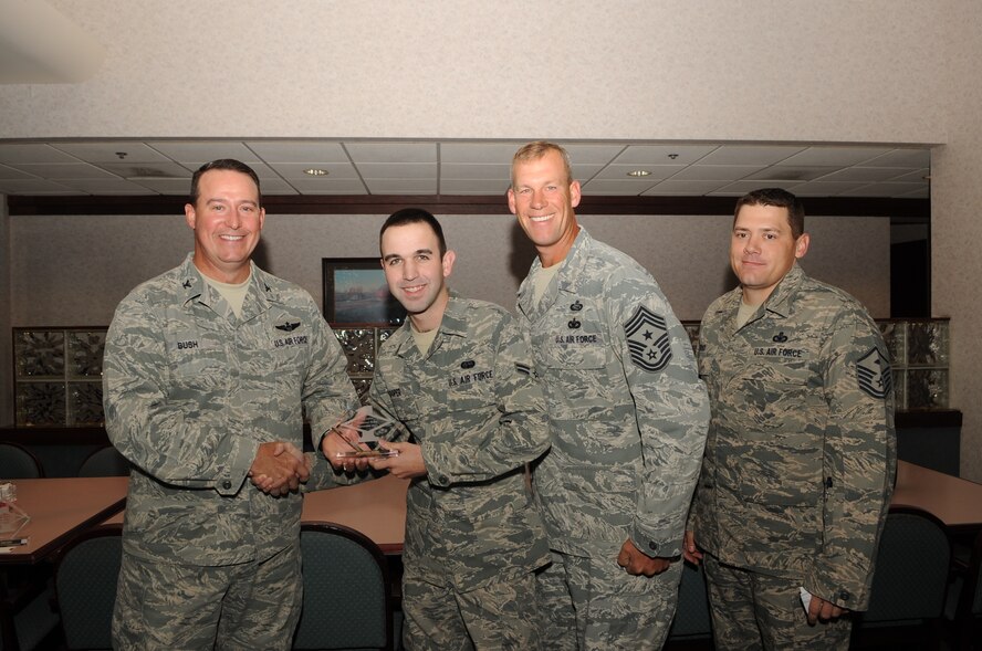 Col. Timothy Bush, 319th Air Base Wing commander, presents Airman 1st Class Charles Cooper, 69th Maintenance Squadron, with a Diamond Sharp Award Sept. 20, 2012, on Grand Forks Air Force Base, N.D., accompanied by 319th ABW Command Chief Master Sgt. David Carlson and Master Sgt. Joseph Rind, 69th MXS First Sergeant. The Diamond Sharp Award is given to Airmen who epitomize service before self and strive for excellence at work and off duty. (U.S. Air Force photo by Staff Sgt. Amanda N. Grabiec)