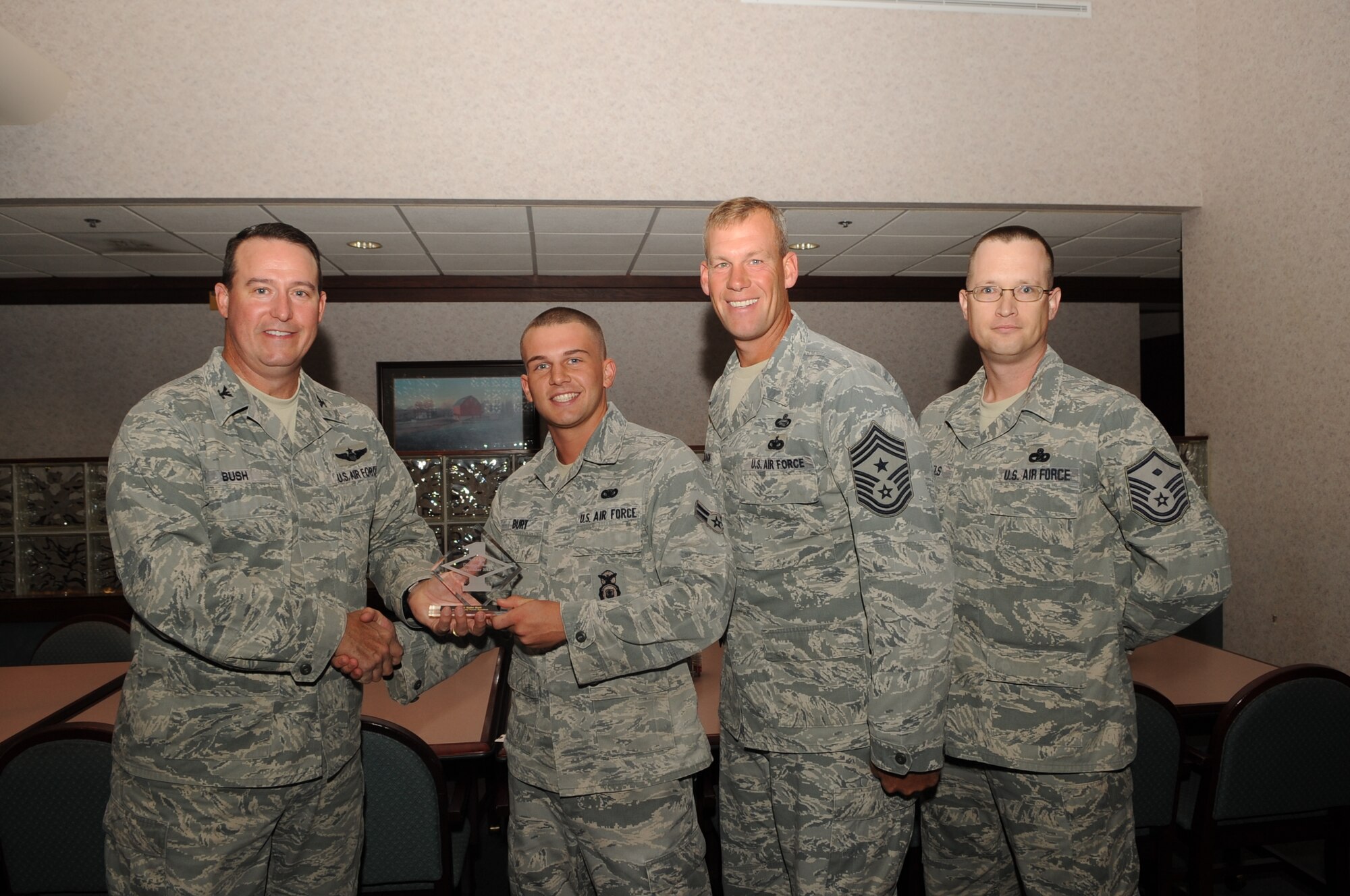 Col. Timothy Bush, 319th Air Base Wing commander, presents Airman 1st Class Tyler Burt, 319th Security Forces Squadron, with a Diamond Sharp Award Sept. 20, 2012, on Grand Forks Air Force Base, N.D., accompanied by 319th ABW Command Chief Master Sgt. David Carlson and Master Sgt. Patrick Michaels, 319th SFS First Sergeant. The Diamond Sharp Award is given to Airmen who epitomize service before self and strive for excellence at work and off duty. (U.S. Air Force photo by Staff Sgt. Amanda N. Grabiec)