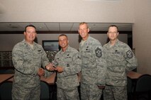 Col. Timothy Bush, 319th Air Base Wing commander, presents Airman 1st Class Tyler Burt, 319th Security Forces Squadron, with a Diamond Sharp Award Sept. 20, 2012, on Grand Forks Air Force Base, N.D., accompanied by 319th ABW Command Chief Master Sgt. David Carlson and Master Sgt. Patrick Michaels, 319th SFS First Sergeant. The Diamond Sharp Award is given to Airmen who epitomize service before self and strive for excellence at work and off duty. (U.S. Air Force photo by Staff Sgt. Amanda N. Grabiec)