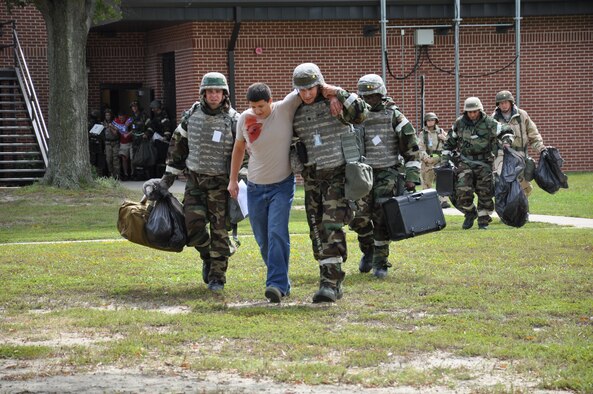 Airmen from the 4th Fighter Wing assist a moulage while evacuating the building after a simulated attack during Phase II of Operational Readiness Exercise Coronet Warrior 12-04 at a simulated deployed location on Seymour Johnson Air Force Base, N.C., Sept. 20, 2012. Moulages, or personnel with mock injuries, were used frequently throughout the exercise to make scenarios more realistic. (U.S. Air Force photo/Staff Sgt. Courtney Richardson/Released)