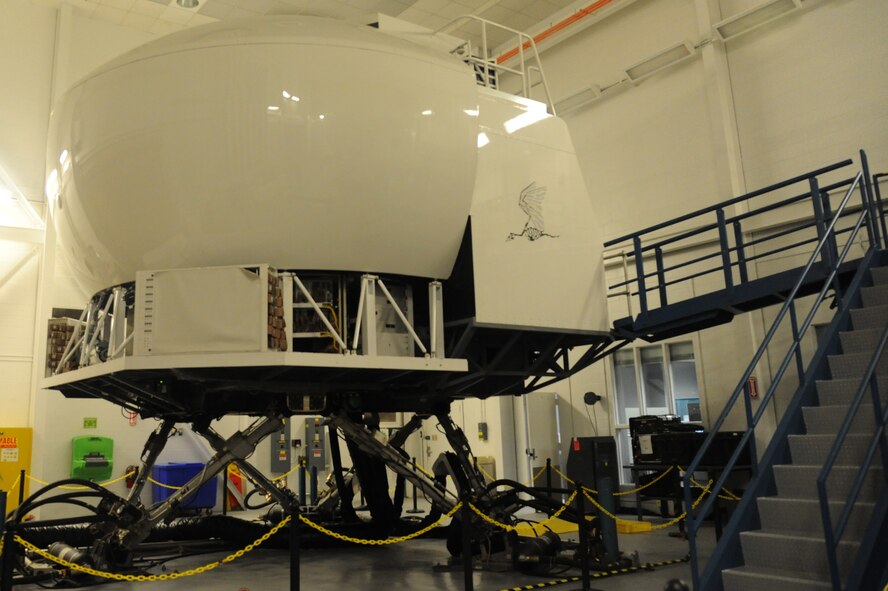 The MC-130E Combat Talon I simulator sits in one of the simulator bays Sept. 20, 2012 at Hurlburt Field, Fla. Since all of the simulators look the same from the outside, they are identified by a specific emblem. For example, this simulator is marked with a pterodactyl dinosaur. (U.S. Air Force photo by Senior Airman Melanie Holochwost)   