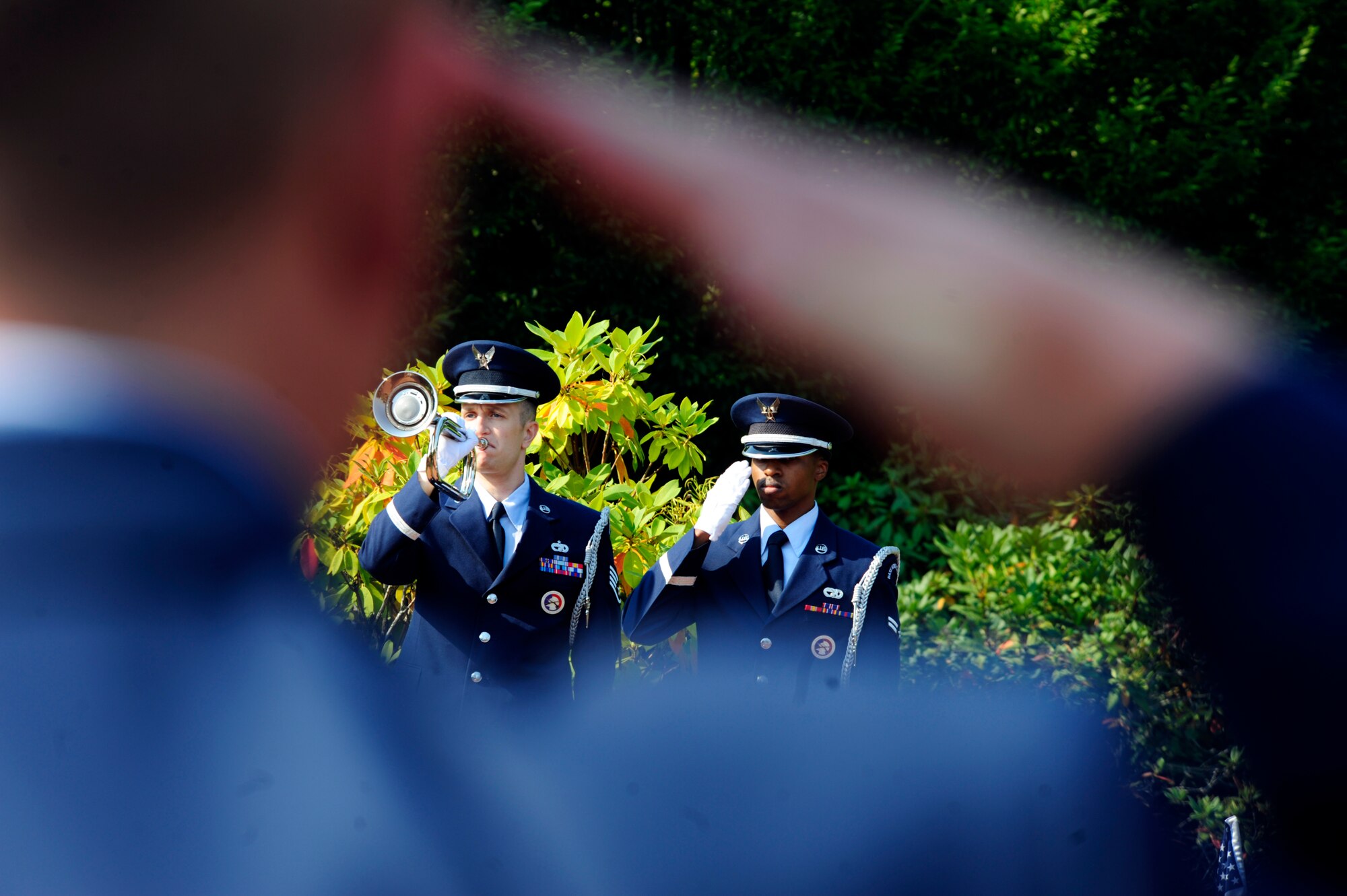 Staff Sgt. Stephen Cooper, 62nd Airlift Wing base honor guard bugler and Airman 1st Class Antonio Lee, 62nd AW honor guard member pay their respects during the Sept. 17, 2012 POW/MIA remembrance ceremony at Memorial Grove park, Joint Base Lewis-McChord, Wash. The remembrance ceremony was the kick-off event for a week long remembrance of POWs/MIAs at McChord Field. (U.S. Air Force photo/Master Sgt. Todd Wivell)
