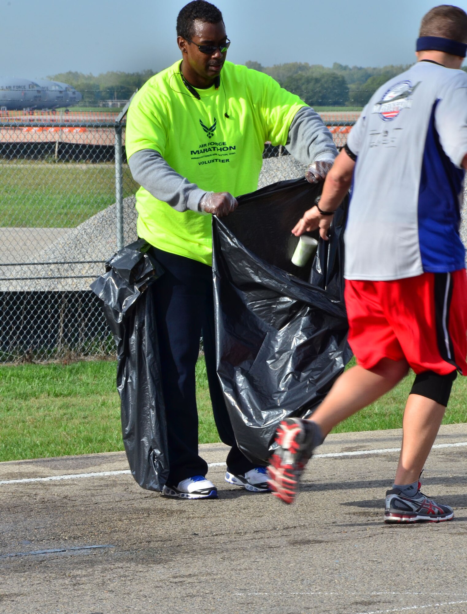 WRIGHT-PATTERSON AIR FORCE BASE, Ohio – Master Sgt. Edward Benton, 445th Airlift Wing knowledge operations management, collects used cups and banana peels thrown away by runners participating in the 2012 Air Force Marathon Sept. 15. Wing volunteers manned a hydration station with other volunteers along the route to provide the runners a drink and a snack along their way to the finish line. (U.S. Air Force photo/Staff Sgt. Amanda Duncan)
