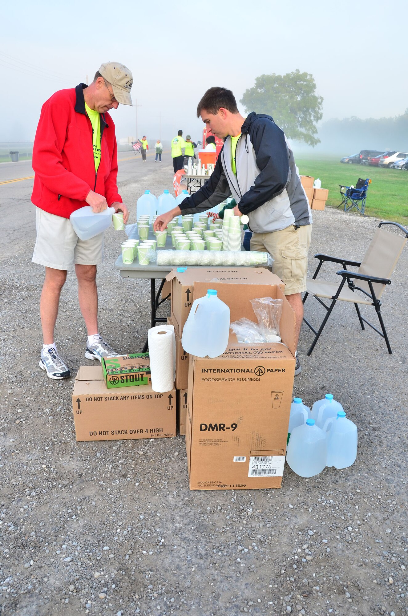 WRIGHT-PATTERSON AIR FORCE BASE, Ohio – Col. Stephen Goeman (left), 445th Airlift Wing commander, pours water into cups to be passed out to runners participating in the 2012 Air Force Marathon Sept. 15. Wing volunteers manned a hydration station with other volunteers along the route to provide the runners a drink and a snack along their way to the finish line. (U.S. Air Force photo/Staff Sgt. Amanda Duncan)