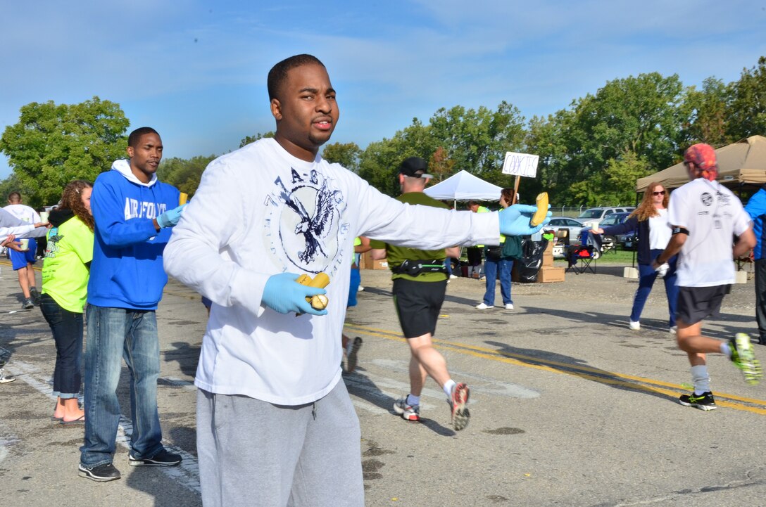 WRIGHT-PATTERSON AIR FORCE BASE, Ohio – Senior Airman Cordell Washington, 445th Services Sustainment Flight services apprentice, gives bananas to runners participating in the 2012 Air Force Marathon Sept. 15. Wing volunteers manned a hydration station with other volunteers along the route to provide the runners a drink and a snack along their way to the finish line. (U.S. Air Force photo/Staff Sgt. Amanda Duncan)