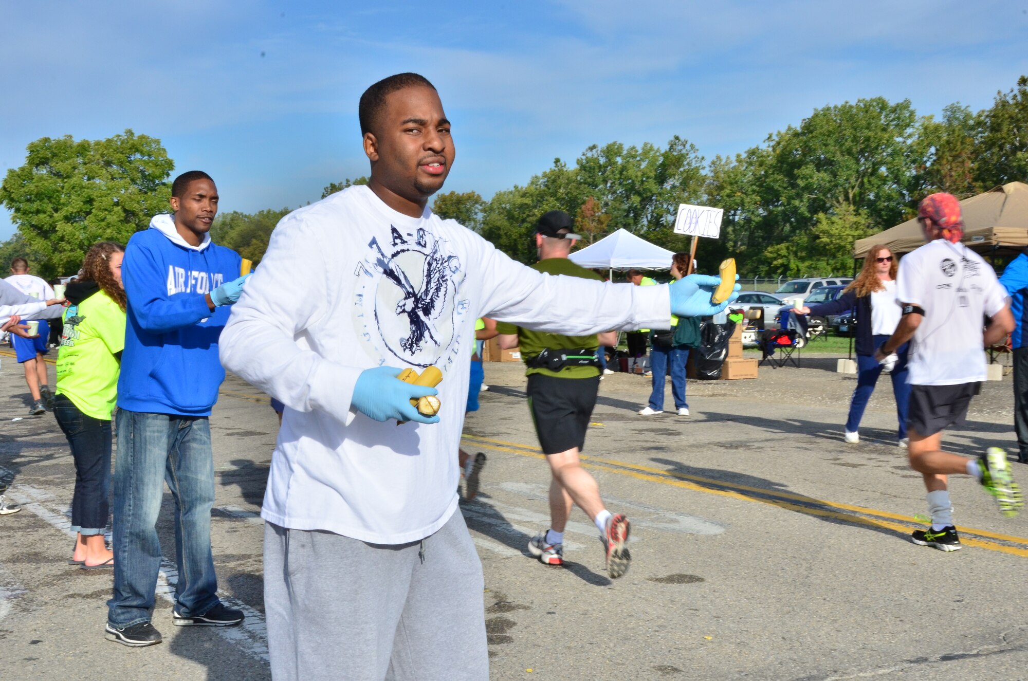 WRIGHT-PATTERSON AIR FORCE BASE, Ohio – Senior Airman Cordell Washington, 445th Services Sustainment Flight services apprentice, gives bananas to runners participating in the 2012 Air Force Marathon Sept. 15. Wing volunteers manned a hydration station with other volunteers along the route to provide the runners a drink and a snack along their way to the finish line. (U.S. Air Force photo/Staff Sgt. Amanda Duncan)