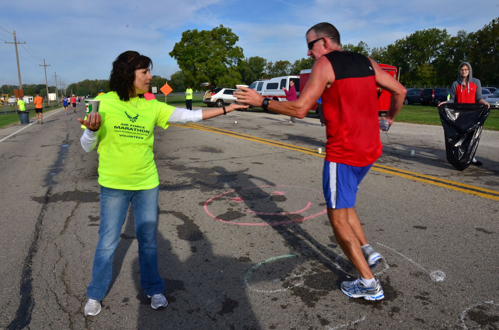 WRIGHT-PATTERSON AIR FORCE BASE, Ohio – Senior Master Sgt. Rose Harris, 445th Aerospace Medicine Squadron career advisor, hands a sports drink to a runner participating in the 2012 Air Force Marathon Sept. 15. Wing volunteers manned a hydration station with other volunteers along the route to provide the runners a drink and a snack along their way to the finish line. (U.S. Air Force photo/Staff Sgt. Amanda Duncan)