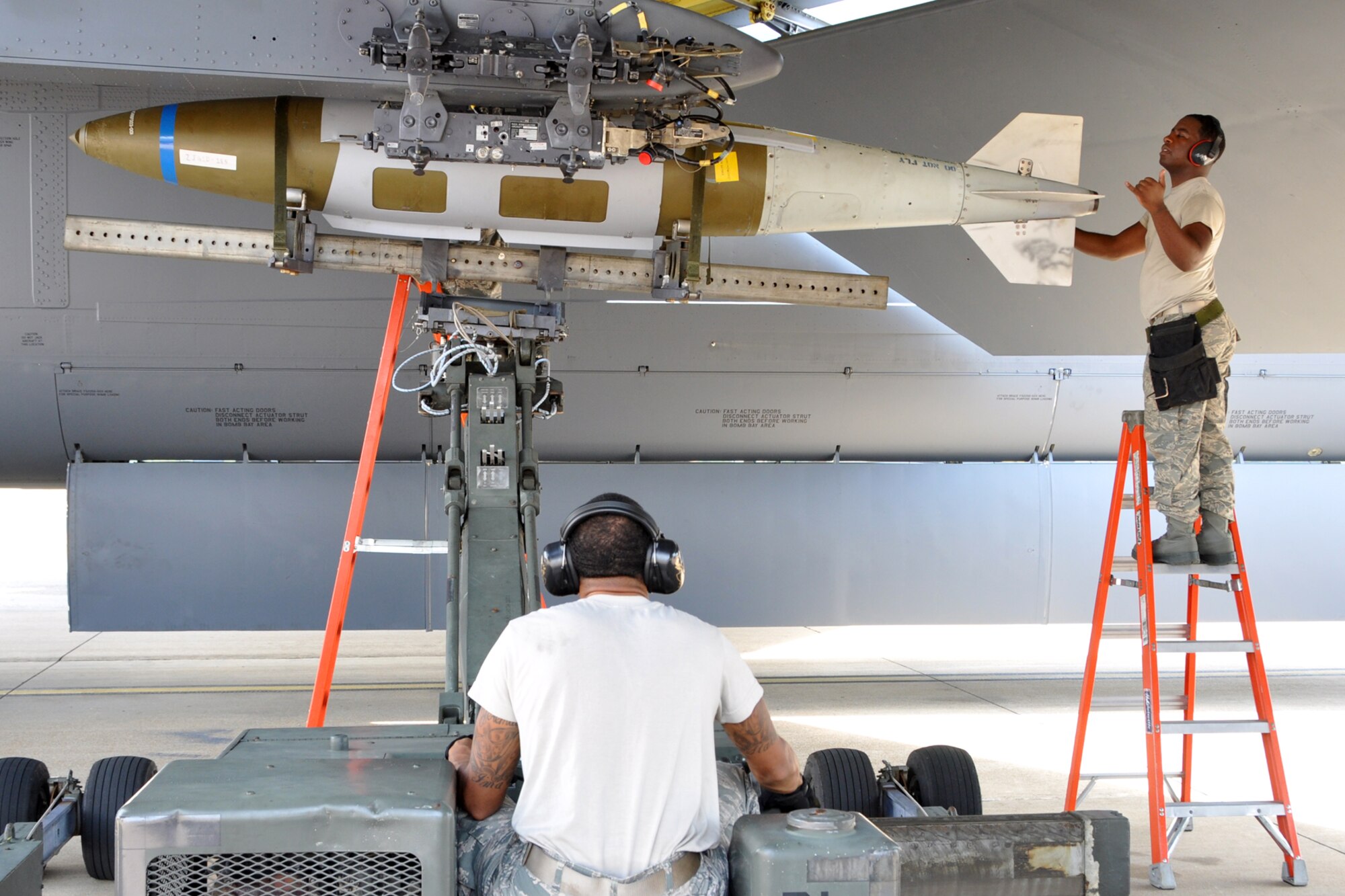 Senior Airman Coreyaunte Hayes guides Senior Airman Tyshaun Owens as they load a GB U-31 bomb onto a B-52 Stratofortress at Barksdale Air Force Base, La., Sept. 13, 2012. Both Airmen are weapons loaders assigned to the 307th Maintenance Squadron. They were participating in the weapons loading portion of the 2012 annual Global Strike Challenge at Barksdale. (U.S. Air Force photo by Master Sgt. Jeff Walston)   