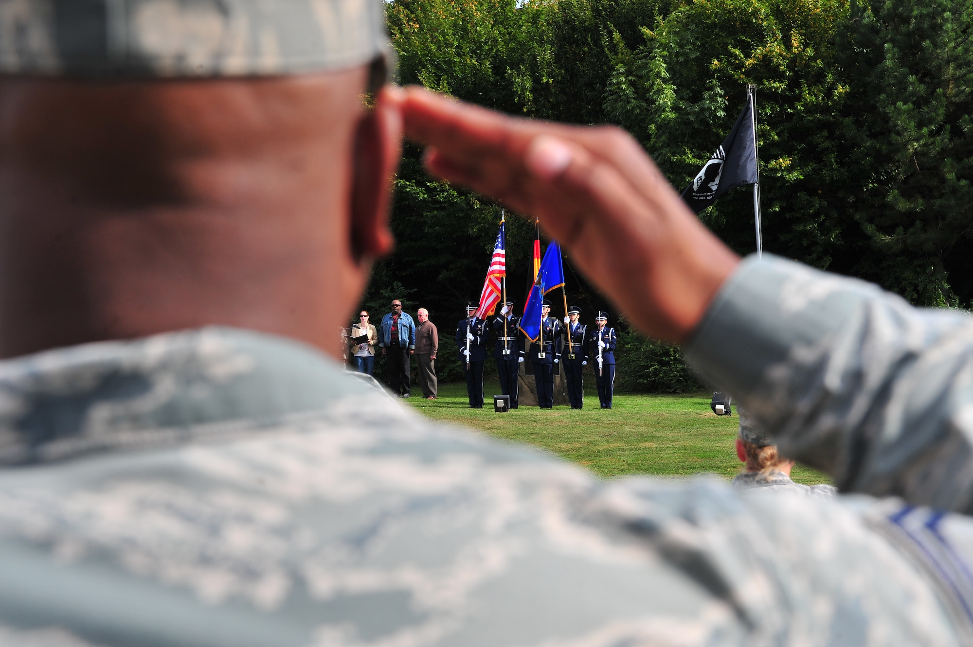 SPANGDAHLEM AIR BASE, Germany – Members of the 52nd Fighter Wing Honor Guard post the colors as 52nd FW members salute during the Prisoner of War Missing in Action Ceremony at the air park here Sept. 21. The ceremony is held every year to remember those who have served and been taken prisoner or have been listed as MIA. (U.S. Air Force photo by Airman 1st Class Dillon Davis/Released)