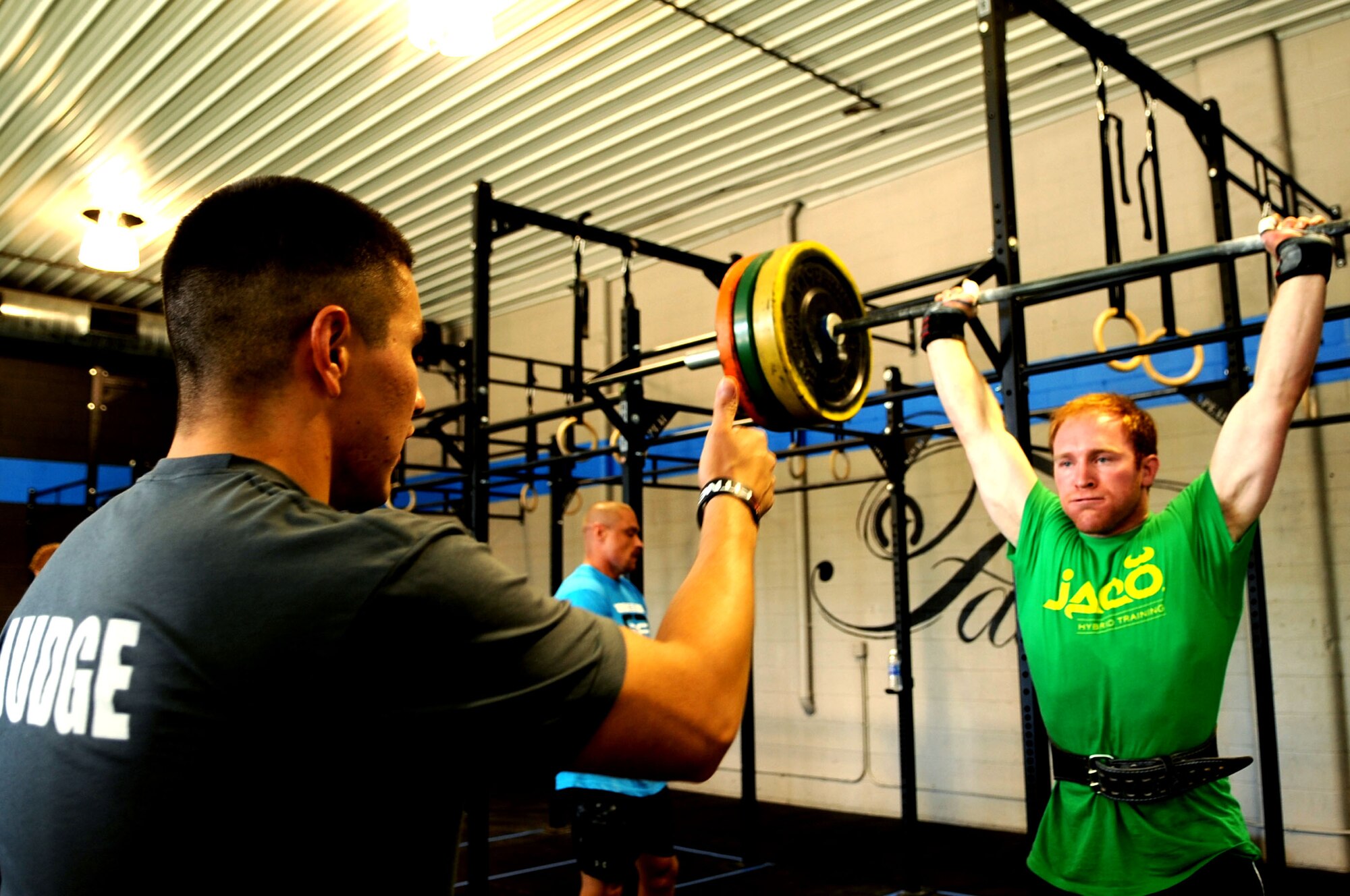 Senior Airman Abel Vazquez, 319th Civil Engineer Squadron, gives thumbs up to a competitor after completing a movement correctly during the Cloudy Town Throw CrossFit competition in St. Cloud, Minn., Sept. 15, 2012. CrossFit is a training system composed of functional movements that are used in daily lives such as lifting and jumping. (U.S. Air Force photo by Staff Sgt. Amanda N. Grabiec)