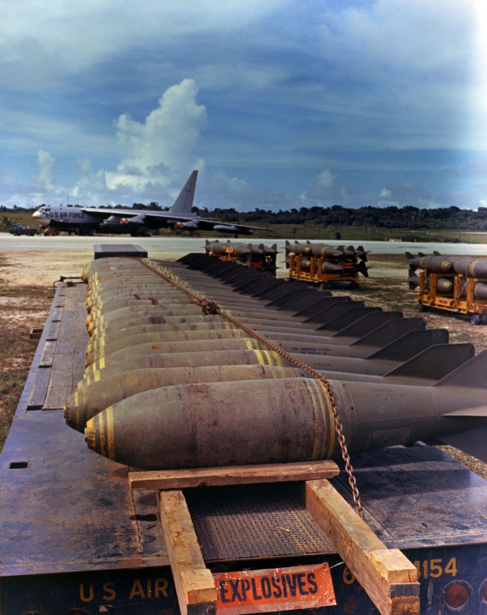 Bombs without fuses ready to be loaded onto the B-52 in the background. (U.S. Air Force photo)