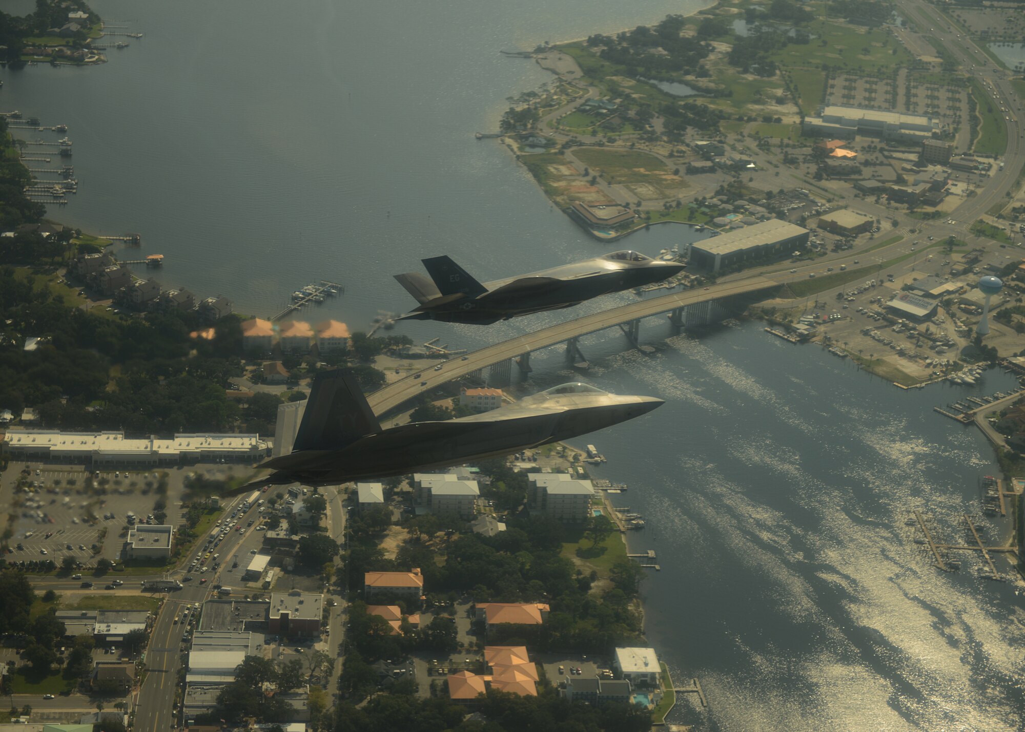 An F-35A Lightning II joint strike fighter, top, from the 33rd Fighter Wing at Eglin Air Force Base, Fla., and an F-22A Raptor from the 325th Fighter Wing at Tyndall Air Force Base, Fla., soar over the Emerald Coast on Sept. 19, 2012. This was the first time the two fifth-generation fighters have flown together for the Air Force. (U.S. Air Force photo/Master Sgt. Jeremy T. Lock)