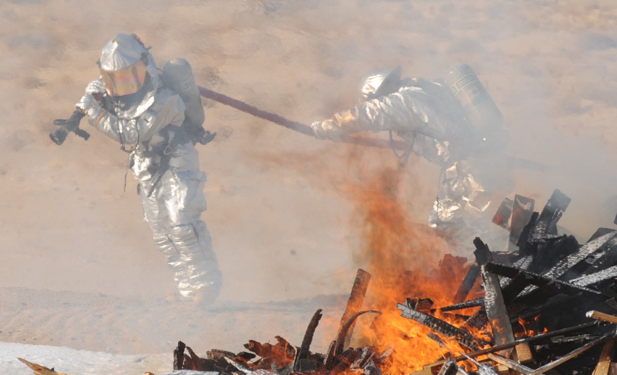 SOUTHWEST ASIA – Members of the 386th Expeditionary Civil Engineer Squadron fire department prepare to fight a fire on the ground during the live-burn portion of the major accident response exercise here Sept.18. The 386th ECES Explosive Ordnance Disposal team set up two live burn pits for both the U.S. Air Force and host nation fire departments for the exercise to test their ability to respond and extinguish a fire in a required amount of time. (U.S. Air Force photo/Staff Sgt. Alexandra M. Boutte)