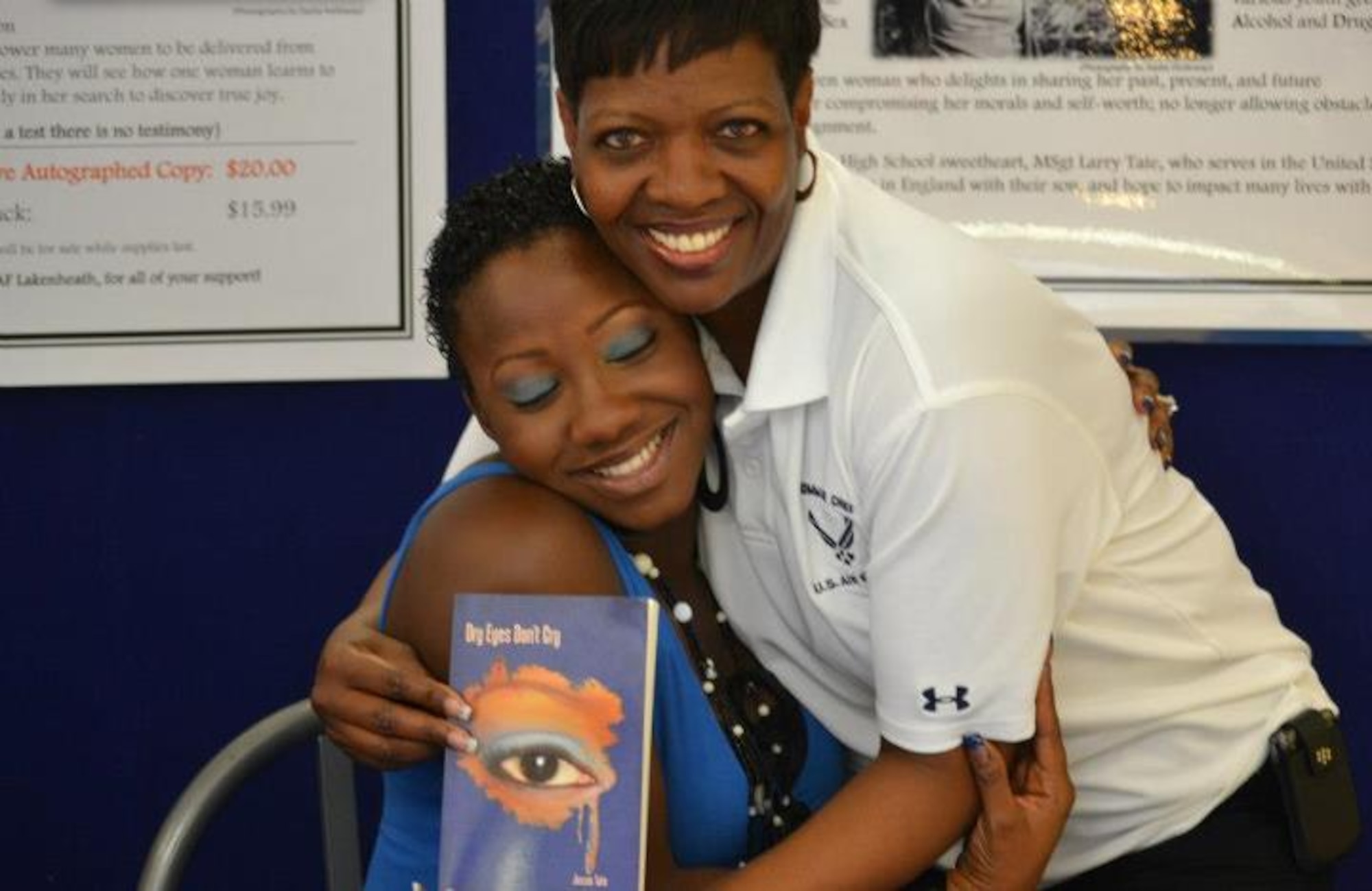 ROYAL AIR FORCE LAKENHEATH, England -- Jessie Tate (left) and Chief Master Sgt. SaRita Lathan, 48th Fighter Wing command chief, hug during Tate’s book signing Aug. 18. Tate is an Air Force dependent who recently published a book about her experiences as a young adult. (Courtesy photo)