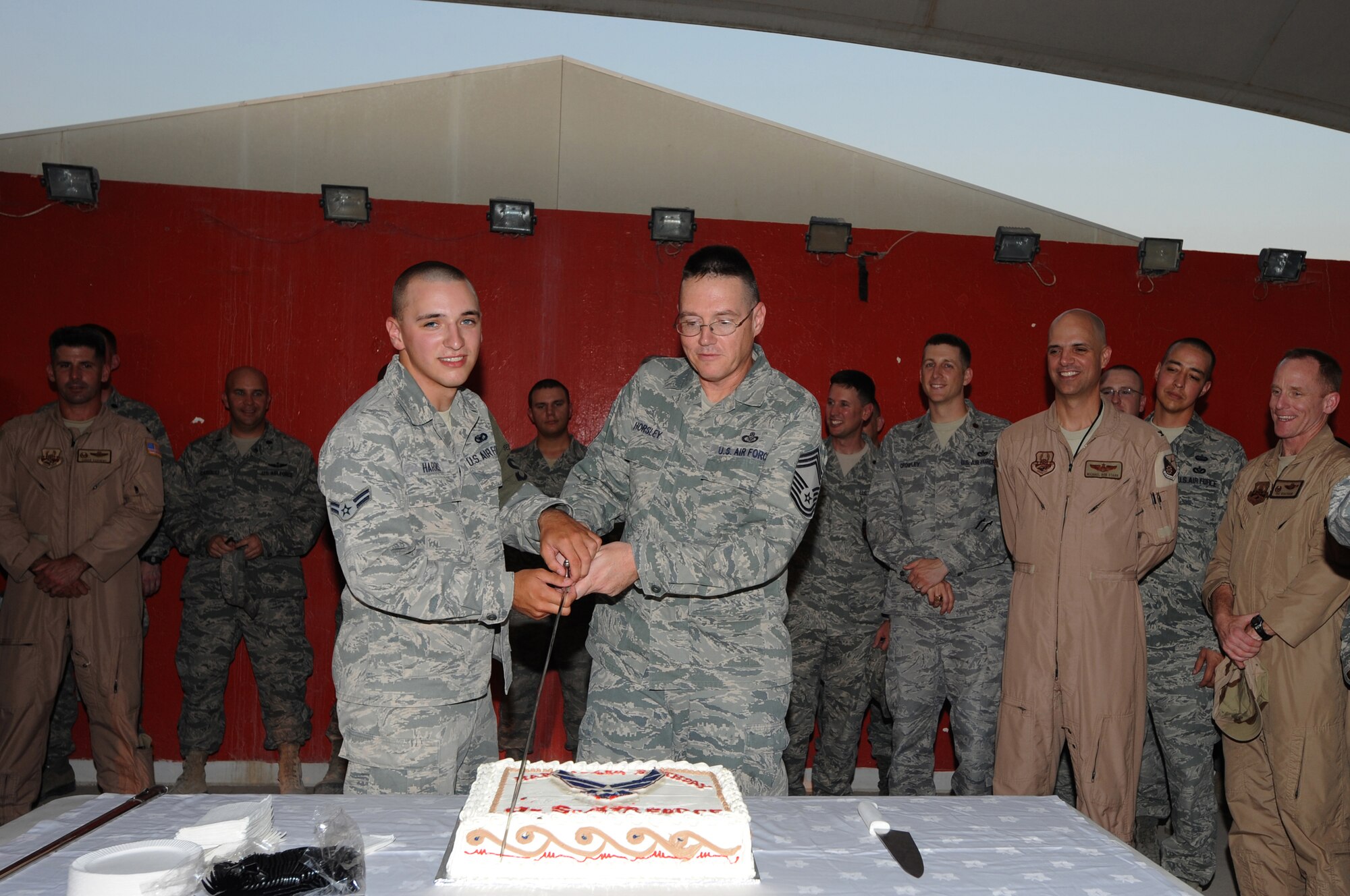 U.S. Air Force Airman 1st Class Brian Harris, 379th Expeditionary Security Forces Squadron, cuts a birthday cake with Chief Master Sgt. Virgil Horsley, 71st Expeditionary Air Control Squadron, to celebrate 65th Birthday of the Air Force in Southwest Asia, September 18, 2012. Harris and Horsley are the youngest and oldest serving airmen joining the service in Oct 4, 2011 and April 7, 1983 respectively here. (U.S. Air Force photo/Staff Sgt. Sheila deVera)