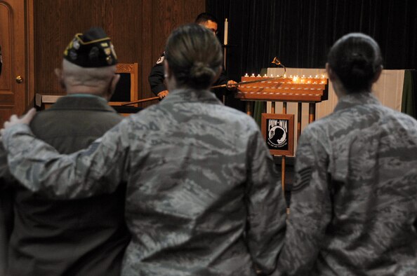 Tech. Sgt. Autum Curran and Tech. Sgt. Crystal Lundell, members of the 51st Logistics Readiness Squadron, provide comfort to a veteran at a Prisoner Of War/Missing In Action candlelight vigil at the Osan Air Base chapel, Republic of Korea, Sept. 19, 2012. Osan held several events, to include a 24-hour run and retreat ceremony, to commemorate POW/MIA week. (U.S. Air Force photo/Staff Sgt. Craig Cisek)