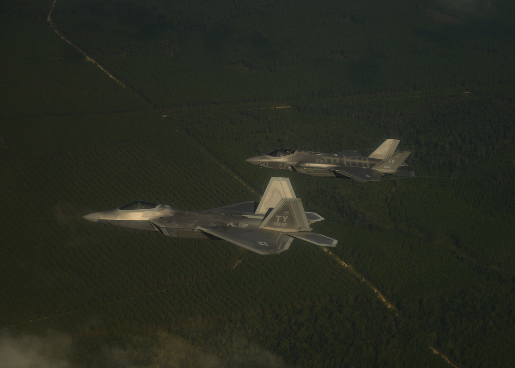 An F-22A Raptor, foreground, from the 43rd Fighter Squadron at Tyndall Air Force Base, Fla., and an F-35A Lightning II joint strike fighter from the 33rd Fighter Wing at Eglin Air Force Base, Fla., soar over the Emerald Coast Sept. 19, 2012. This was the first time the two fifth-generation fighters have flown together for the Air Force. (U.S. Air Force photo/Master Sgt. Jeremy T. Lock)
