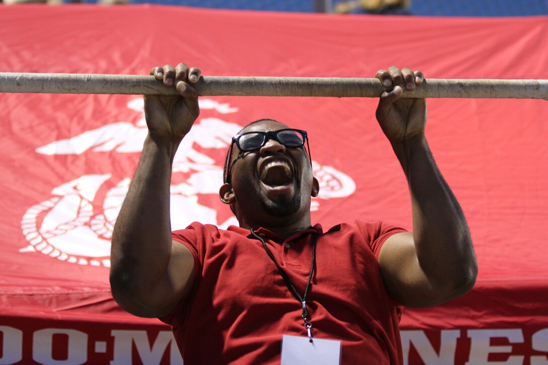 An attendee of the Thursday Night Lights high school football series tries his luck at the Marine Corps Pull-up Challange.