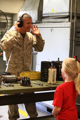 Lance Cpl. Evan N. Burgos, a basic electrical engineer equipment systems technician with 2nd Maintenance Battalion, 2nd Marine Logistics Group, jokingly tests his hearing protection as a visitor to the battalion’s open house attempts to ask questions about the tools he uses to perform his mission aboard Camp Lejeune, N.C., Sept. 19, 2012. Burgos and other personnel with the battalion spent the day demonstrating the types of activities they perform to support units aboard the base in order to provide families and friends with a better understanding of their day-to-day lives. 