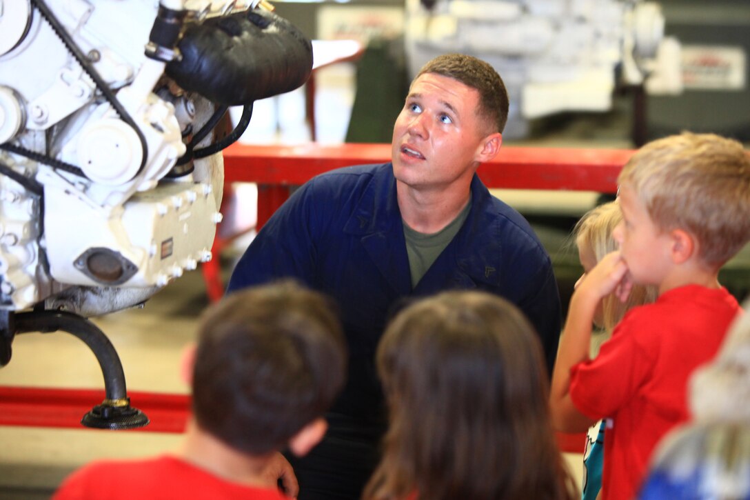 Cpl. Richard A. Herdman, a Light Armored Vehicle mechanic with 2nd Maintenance Battalion, 2nd Marine Logistics Group, answers questions about the LAV engine on display for the battalion’s open house aboard Camp Lejeune, N.C., Sept. 19, 2012. The battalion opened the doors to its facilities in order to provide families and visitors with a better understanding of what their Marines do on a daily basis and promote unit cohesion.