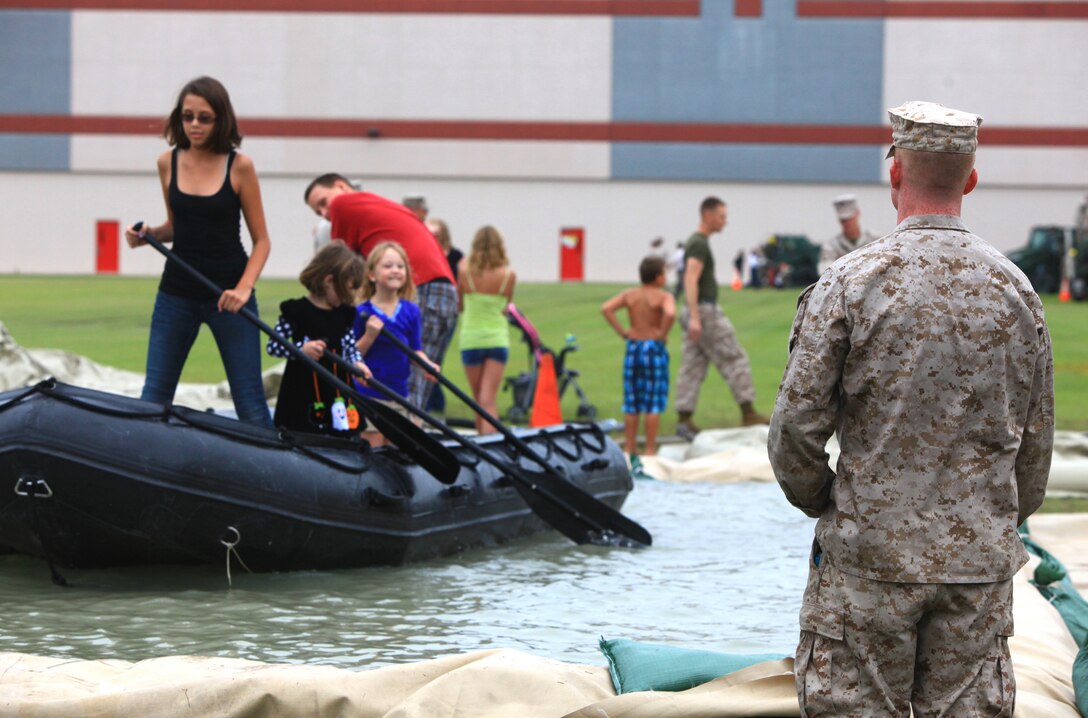 Cpl. John A. L. Silkey, a heavy equipment mechanic with 2nd Maintenance Battalion, 2nd Marine Logistics Group, watches over a group of visitors as they struggle to navigate their zodiac on a man-made pool set up for the battalion’s open house aboard Camp Lejeune, N.C., Sept. 19, 2012. Each of the battalion’s six companies set up stations for families and friends, which allowed them to experience some of the things their Marines do to support operations aboard the base. 
