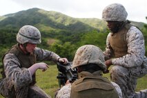 From left, Pfc. Patrick S. Riedy, Lance Cpl. Miguel A. Barbosasalas and Lance Cpl. Curtis K. Brown discuss the MK19 40 mm grenade launcher before a competition during training at Camp Hansen Sept. 12. Marines split into teams of three to conduct assembly and disassembly drills against each other, testing the knowledge they had learned throughout the day. The Marines are ammunition technicians with 3rd Supply Battalion, Combat Logistics Regiment 35, 3rd Marine Logistics Group, III Marine Expeditionary Force.