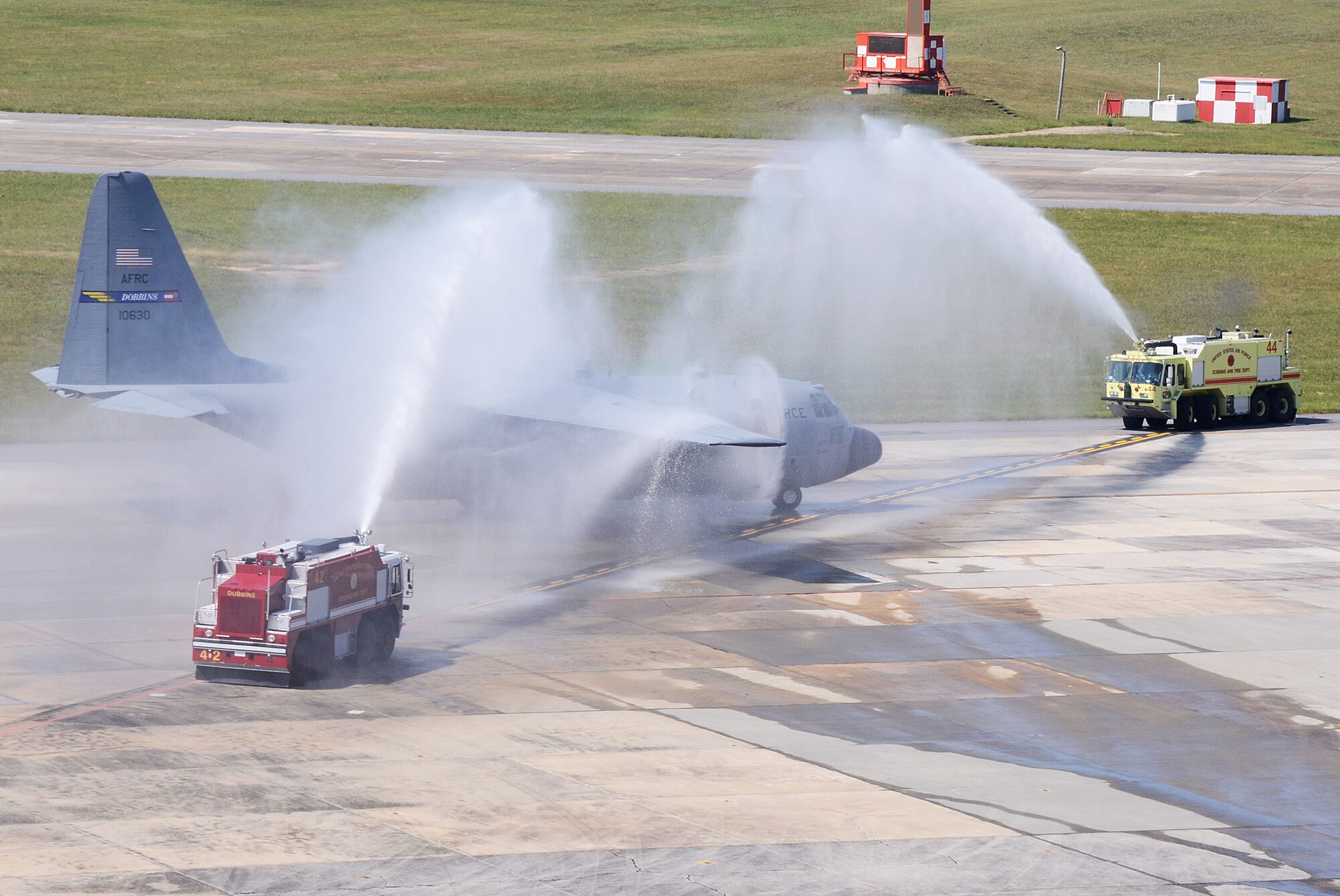The Dobbins Fire Department hoses down a returning C-130H during a homecoming ceremony at Dobbins Air Reserve Base Sept. 22. Over 100 Reservists are scheduled to return to Dobbins ARB from the Middle East Sept. 21-24. The Aircrews flew missions into Egypt, Turkey, Lebanon, Djibouti, Oman, Bahrain, United Arab Emirates, Afghanistan, Yemen, Pakistan and Jordan. (U.S. Air Force photo/Don Peek)