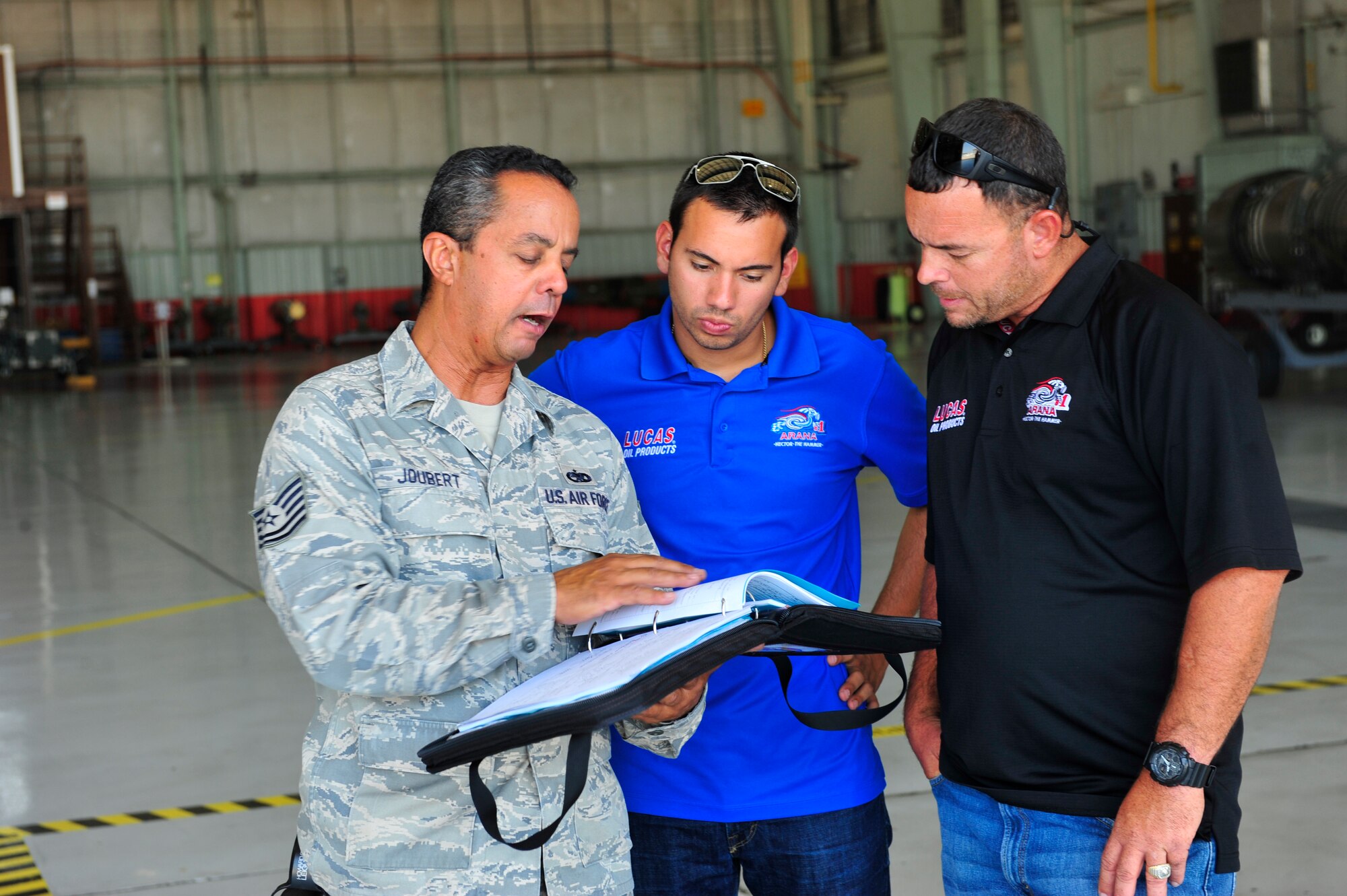 NAVAL AIR STATION FORT WORTH JOINT RESERVE BASE, Texas -- Tech. Sgt. Steven Joubert, 301st Aircraft Maintenance Squadron crew chief, briefs Hector Arana Jr. and Dan Gonzalez about the F-16 during a tour Sept. 20. Arana, National Hot Rod Association Pro-Stock Motorcycle Racing Rookie of the Year in 2011, and his team are in the Dallas area for the AAA Texas NHRA Fall Nationals drag race at Texas Motorplex in Ennis, Texas. (U.S. Air Force photo/Senior Airman Martha Whipple)