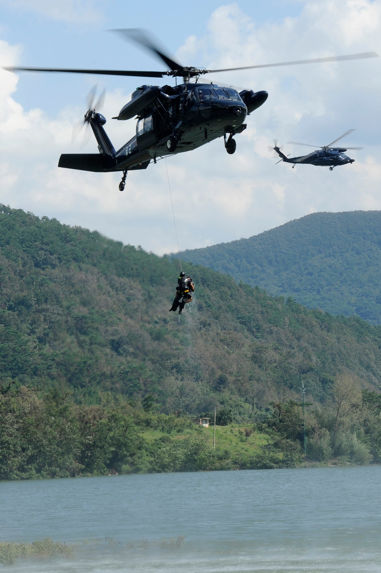 A Republic of Korea Air Force rescue team lifts Lt. Col. Jeremy Quatacker, 8th Fighter Wing chief of safety, Kunsan Air Base, Republic of Korea, from the Okjeongho Reservoir, Gunsan, ROK, Sept. 19, 2012, during combat water survival training. This training teaches pilots how to signal for help, evade the enemy and get rescued by pararescuemen. (U.S. Air Force photo/Senior Airman Marcus Morris)
