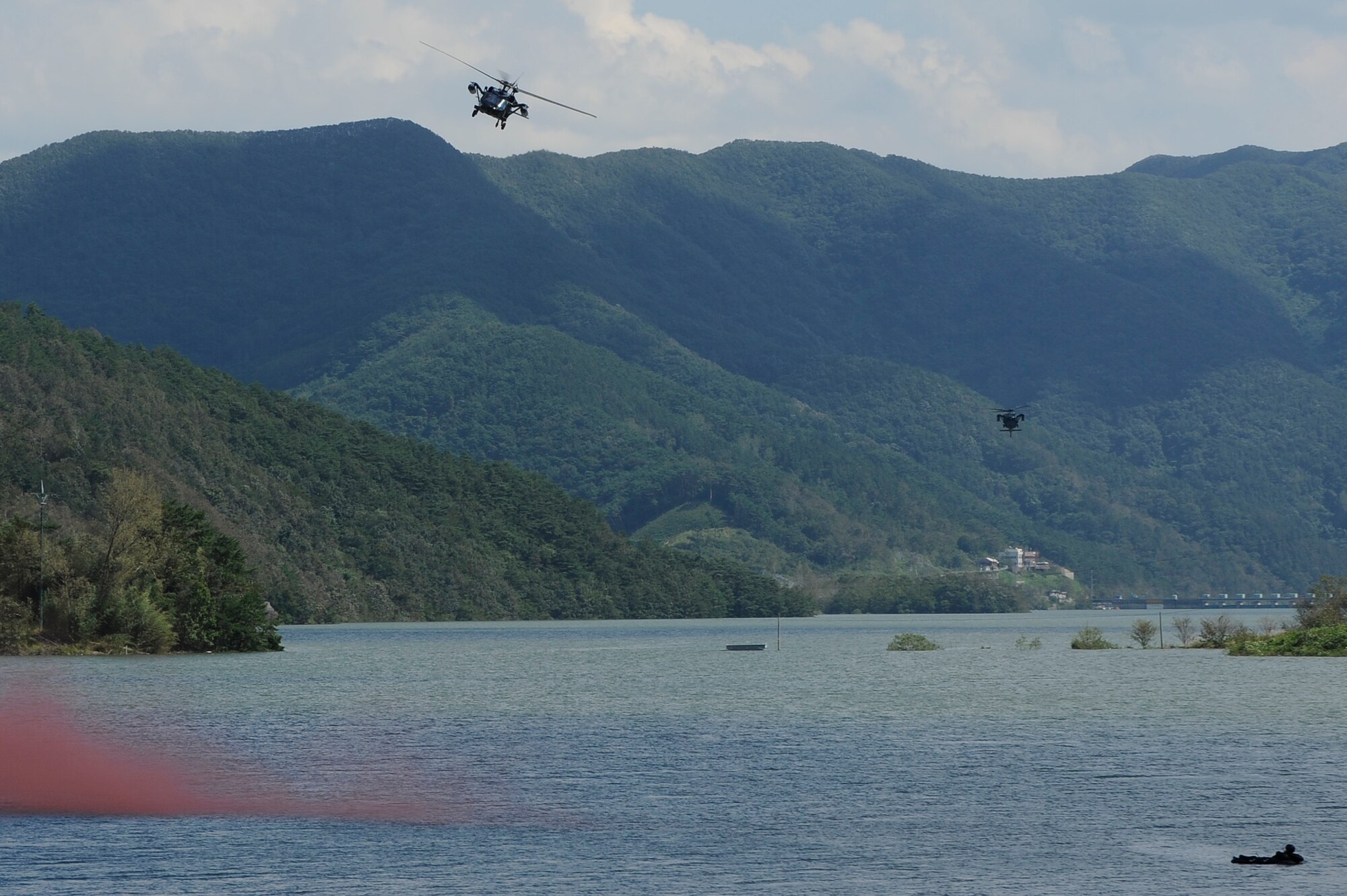 Lt. Col. Jeremy Quatacker, 8th Fighter Wing chief of safety from Kunsan Air Base, Republic of Korea, signals a Republic of Korea Air Force rescue team with a flare at Okjeongho Reservoir, Gunsan, ROK, Sept. 19, 2012. The survival, evasion, resistance and escape training allows RoKAF airmen to practice flying the helicopters and rescuing downed pilots. (U.S. Air Force photo/Senior Airman Marcus Morris)