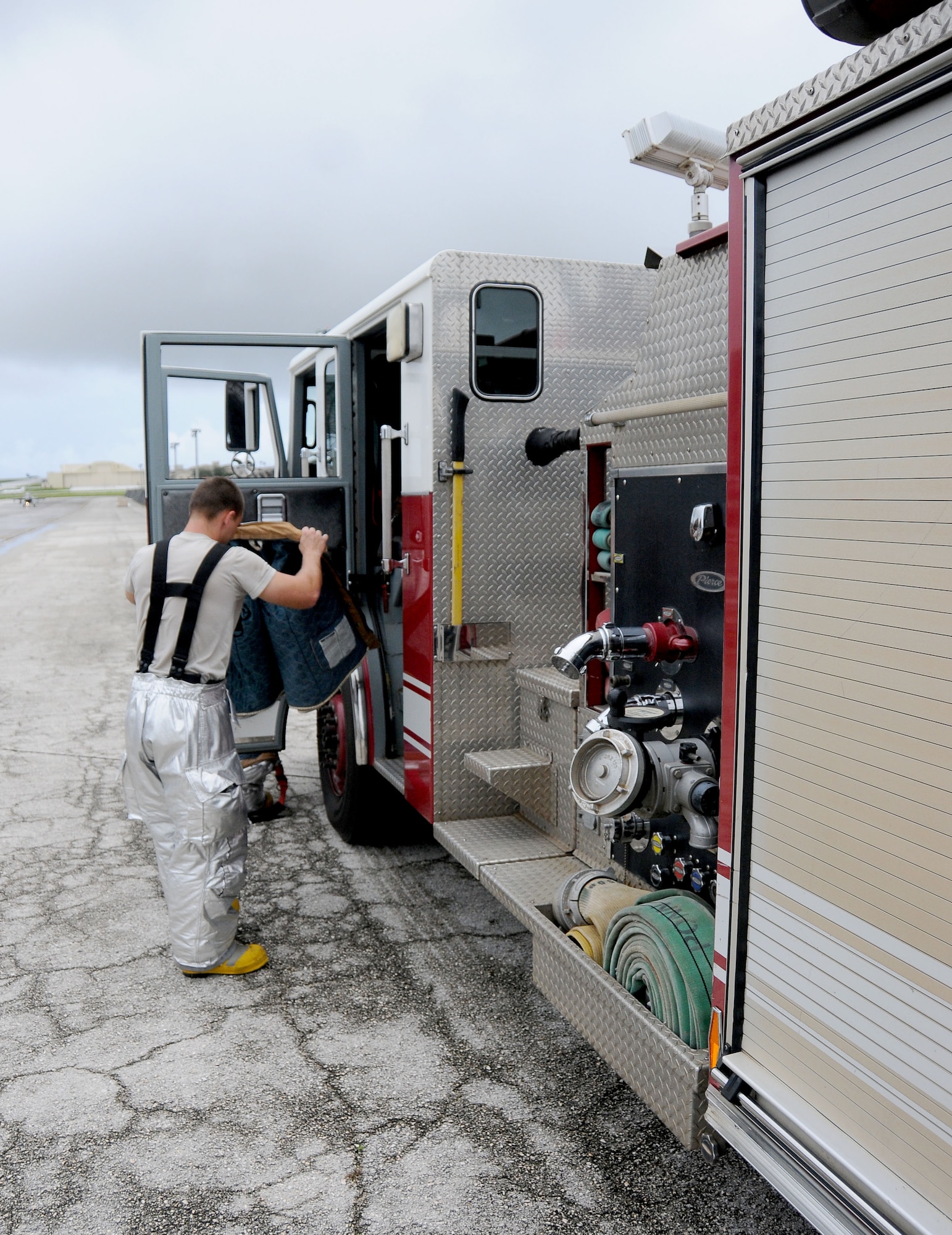 ANDERSEN AIR FORCE BASE, Guam—Airman 1st Class Larry Gish, 36th Civil Engineer Squadron firefighter, dons his personal protective gear in preparation for a in-flight emergency here, Sept. 18. The Andersen Fire Department is trained to respond to a wide variety of scenarios, including but not limited to wild fires, in-flight emergencies, car fires and medical emergencies. (U.S. Air Force photo by Senior Airman Jeffrey Schultze/Released)