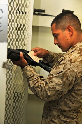 Sergeant Sigilfredo Garcia, armory chief, Command Element, 15th Marine Expeditionary Unit, verifies weapons cards for a Marine's M4A1 service rifle aboard the USS Peleliu, Sept. 20.  The MEU's armory team is made up of four armourers, two optics technicians and nine custodians who work together to ensure the mission readiness of the MEU's armory is always on target. They are tasked with maintaining, repairing, securing, issuing, de-issuing and keeping accountability of the weapons and optics that are aboard. Garcia, 26, is from Lexington, Neb.