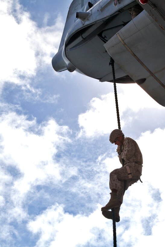 A Marine from the 15th Marine Expeditionary Unit, fast-ropes off the tail of a CH-46E Sea Knight into the hanger bay of the USS Peleliu, Sept. 22.