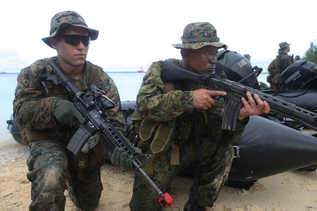 Sgt. Joshua Garcia, squad leader for 2nd squad, 2nd platoon, Company F., Battalion Landing Team 2nd Battalion, 1st Marine Regiment, 31st Marine Expeditionary Unit and naitive of Victorville, Calif., and Sergeant 1st Class Yoshimitsu Shintomi, squad leader and coxon with 1st Company, 51st Infantry Regiment, 15th Brigade, Western Army, Japan Ground Self-Defense Force and native of Kumamoto Prefecture, Japan, hold security next to combat rubber raiding craft during their integrated amphibious raid here, Sept. 22. Working alongside the 31st MEU, the Japanese soldiers conducted various amphibious-borne training evolutions aimed at strengthening both militaries' interoperability. The 31st MEU is the only continuously forward-deployed MEU and is the Marine Corps' force in readiness in the Asia-Pacific region.