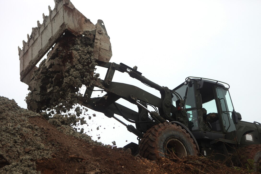 A John Deere TRAM 624KR Tractor, Rubber Tired, Articulated Steering, Multi-purpose vehicle, operated by heavy equipment operator Lance Cpl. Carlos Perezfernandez with Combat Logistics Battalion 31, 31st Marine Expeditionary Unit and a native of West Covina, Calif., unloads a cement and dirt mixture during a humanitarian assistance exercise here, Sept. 23. The HA training operation was conducted during the 31st MEU's certification exercise, where the Marines and Sailors execute multi-national training scenarios throughout the Asia-Pacific region. The 31st MEU is the only continually forward-deployed MEU and is the Marine Corps' force in readiness in the Asia-Pacific region.