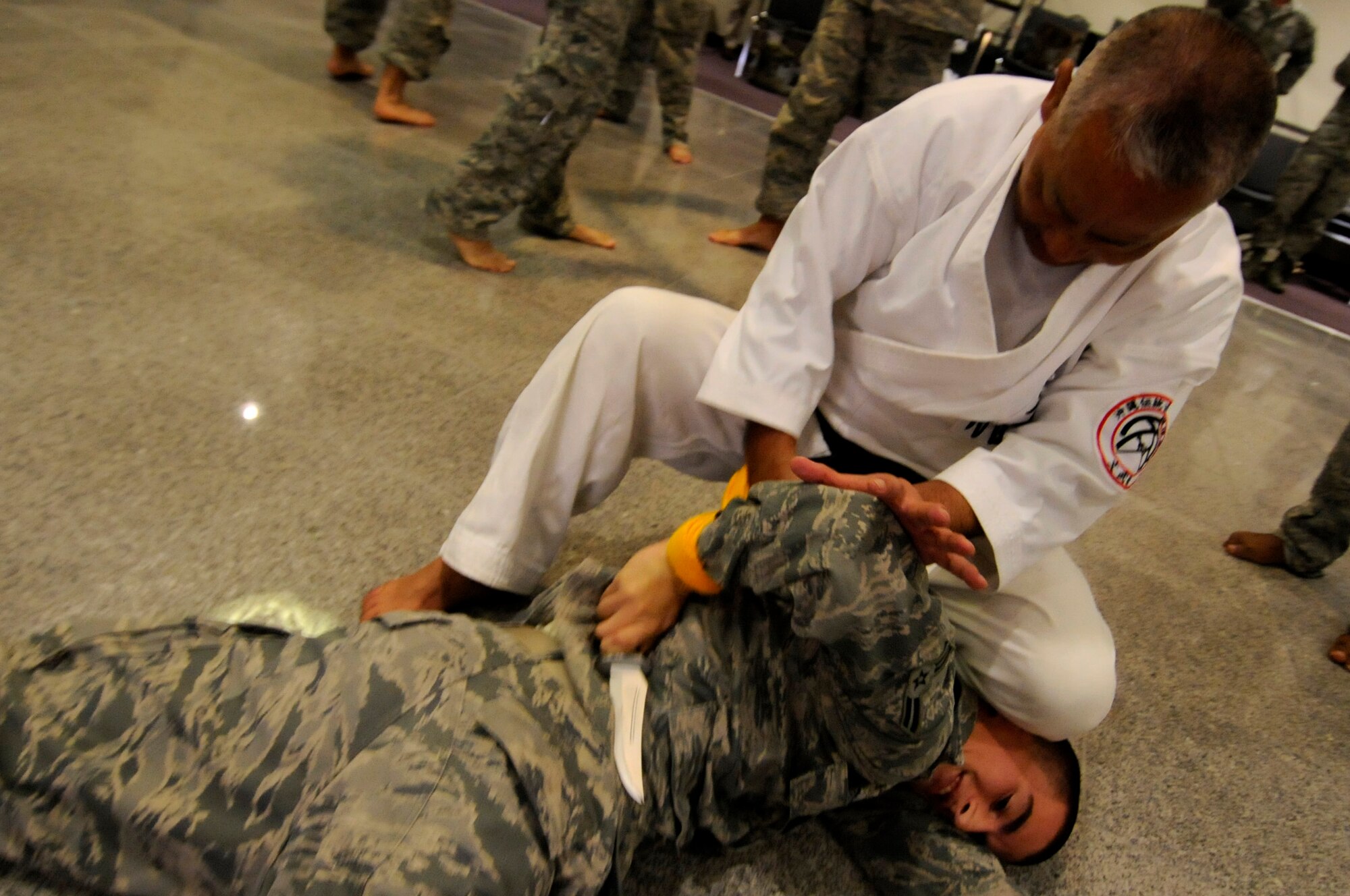 Takashi Nakimori, a Okinawa Traditional Kobudo Preservation Society karate sensei, demonstrates traditional Okinawan karate techniques on an Airman during a cultural seminar at the Schilling Community Center on Kadena Air Base, Japan, Sept. 21. The seminar has been held on base for four years and is sponsored by the Japanese Ministry of Foreign Affairs. (U.S. Air Force photo/Airman Tara A. Williamson)