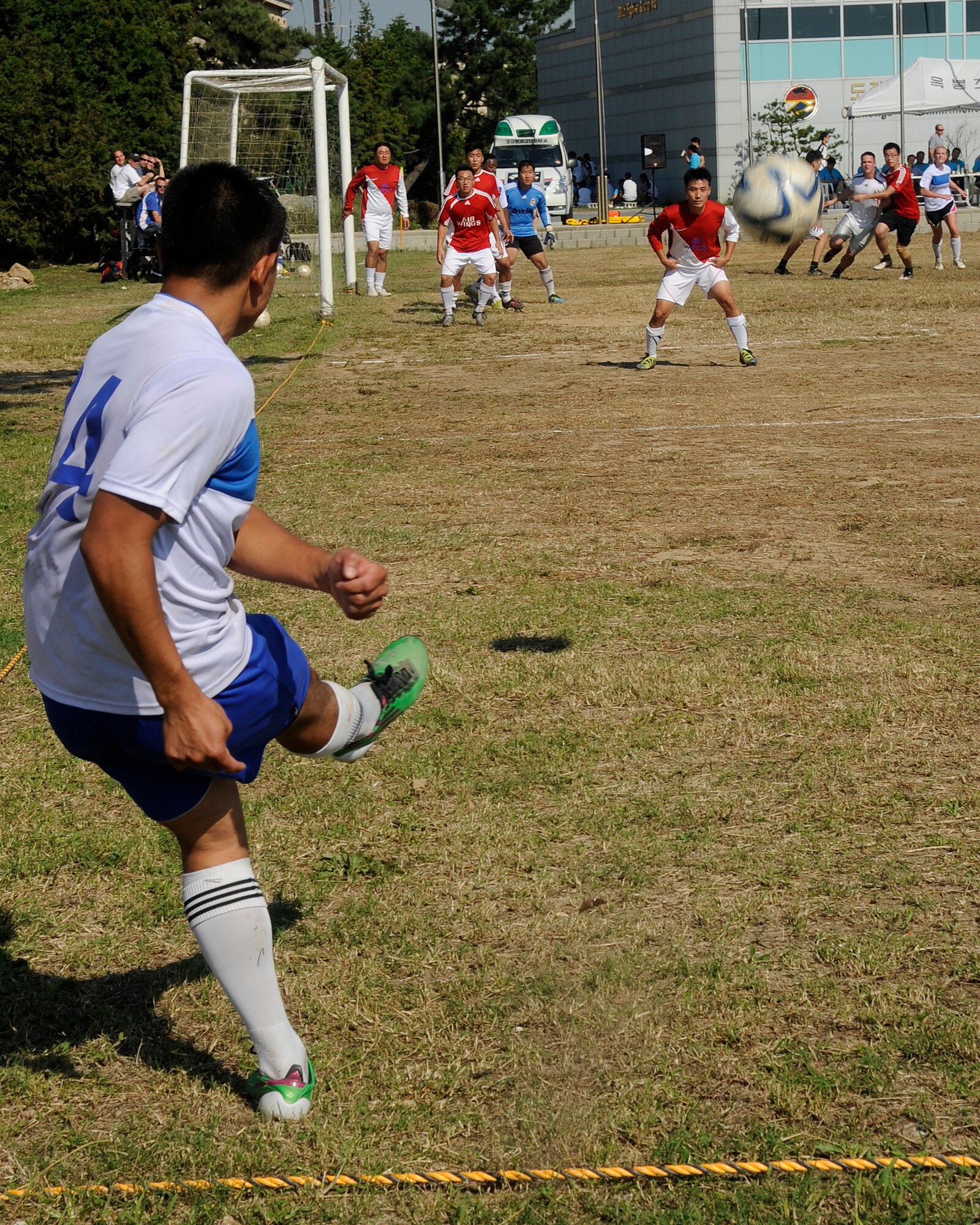 A member from the United States Air Force 8th Fighter Wing corner kicks the ball towards the goal as members of the Republic of Korea 38th Fighter Group try to block the shot at Kunsan Air Base, Republic of Korea, Sept. 20, 2012. The kick assisted a member of the U.S. team to score their first goal of the game. (U.S. Air Force photo/ Senior Airman Marcus Morris)