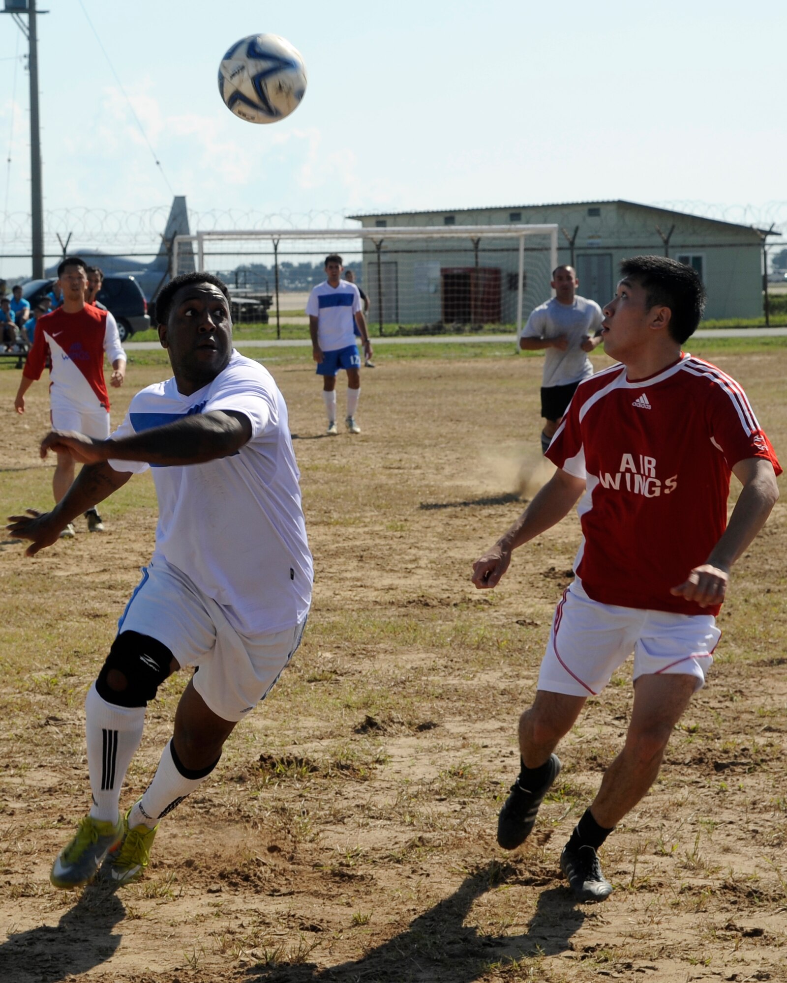 A member  from the United States Air Force 8th Fighter Wing hits the ball towards the goal as a member of the Republic of Korea 38th Fighter Group guards him at Kunsan Air Base, Republic of Korea, Sept. 20, 2012. Although the 8th FW played with intensity, they were no match for the 38th FG and lost one to four.  (U.S. Air Force photo/ Senior Airman Marcus Morris)