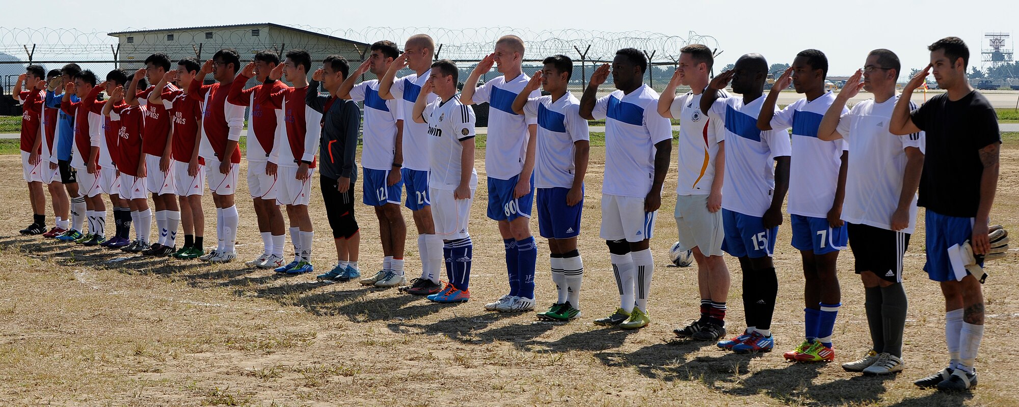 Members of the Republic of Korea Air Force 38th Fighter Group and United States Air Force 8th Fighter Wing salute the crowd before a soccer game at Kunsan Air Base, Republic of Korea, Sept. 20, 2012. The soccer game was one of many games during the Kunsan Olympics to build camaraderie. (U.S. Air Force photo/ Senior Airman Marcus Morris)