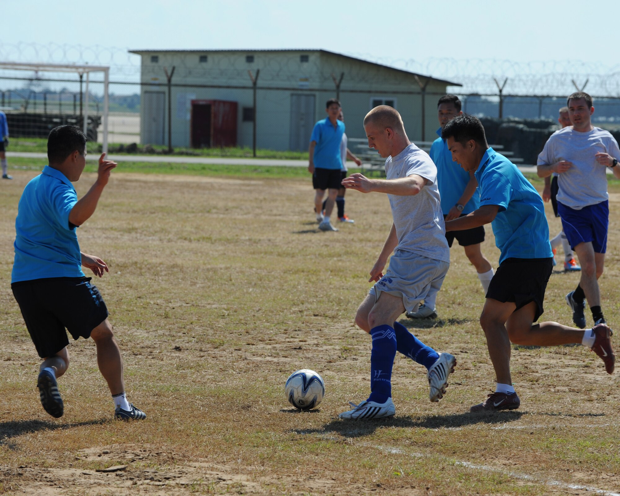 A member  of the United States Air Force commanders team tries to kick a soccer ball past two Republic of Korea Air Force commanders team defenders during 2012 Kunsan Olympics USAF commanders versus RoKAF commanders soccer match on Kunsan Air Base, Republic of Korea, Sept. 20, 2012. The match featured teams made up of primarily wing, group and squadron level commanders and was a friendly competition between the two Air Forces. The RoKAF won the 20 minute match two to one. (U.S. Air Force photo/Staff Sgt. Jonathan Fowler)